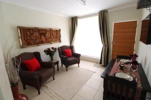 a living room with two chairs and a table at Wilger Guesthouse - Self-Catering Business Accommodation in Centurion in Centurion