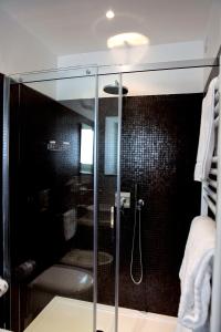 uma casa de banho com um chuveiro e uma porta de vidro em Hotel La Dimora di Piazza Carmine em Ragusa