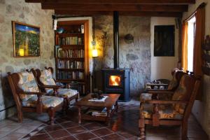 sala de estar con chimenea, sillas y fogones en Terrazas de Cruz Chica. en La Cumbre