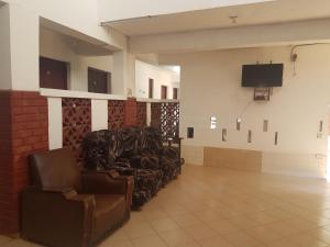 a waiting room with chairs and a flat screen tv at Kwale Golden Guest House in Kwale