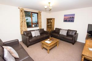a living room with leather couches and a coffee table at Bayview Self-Catering, Lerwick in Lerwick