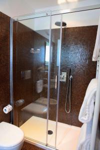a bathroom with a shower, toilet, and sink at Hotel La Dimora di Piazza Carmine in Ragusa