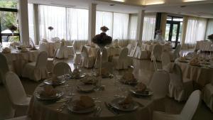 un salón de banquetes con mesas blancas y sillas blancas en Hotel Ristorante La Campagnola, en Cassino