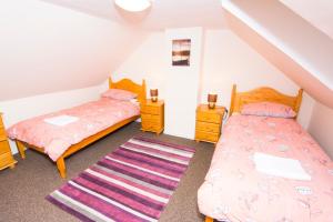 a bedroom with two beds and a rug at Bayview Self-Catering, Lerwick in Lerwick