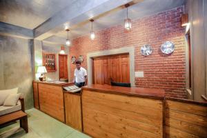 a man standing at a bar in a brick wall at Somerset Mirissa in Mirissa