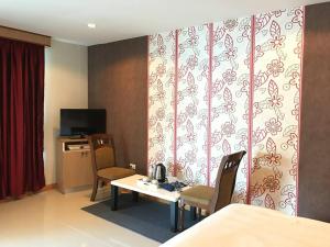 a room with a table and two chairs and a kitchen at Star Residency Hotel in Pattaya
