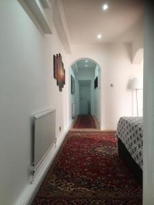 ロンドンにあるLuxurious Apartment in Kensington & Chelseaの廊下(ベッド1台付)、テレビが備わります。
