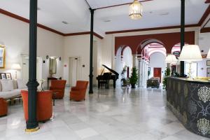 vestíbulo con piano y sala de estar en Sercotel Las Casas de los Mercaderes, en Sevilla