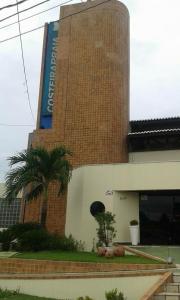 un bâtiment avec un panneau sur son côté dans l'établissement Costeira Praia, à Natal