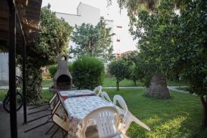 a table and chairs in a yard with a stove at Tzamtzis Apartments in Keramoti