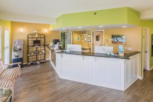 a kitchen with a large white counter and yellow walls at The Islander Inn in Ocean Isle Beach