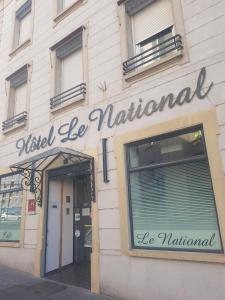 un cartello sul lato di un edificio di Hôtel Le National a Saint-Étienne