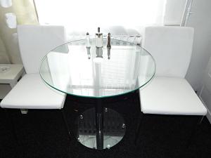 a glass table with two white chairs around it at Apartments Ostrava Vítkovice in Ostrava