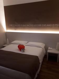 Una cama con un teléfono rojo sentado encima. en Hotel Bigio, en San Pellegrino Terme