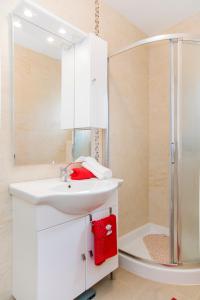 a bathroom with a white sink and a shower at Holiday home Nora in Drače