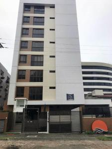 un edificio blanco alto con una puerta delante en Apartamento em João Pessoa a Poucos Metros do Mar, en João Pessoa