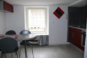 a kitchen with a table and chairs and a window at Meublé Celtic in Niederbronn-les-Bains +3 photos