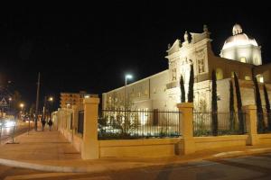 un gran edificio blanco con una torre de reloj por la noche en Della torre rooms, en Lecce