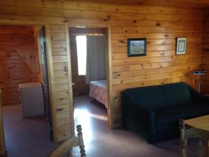 1 dormitorio con 1 cama y 1 silla en una cabaña en Sea'scape Cottages en Bayfield