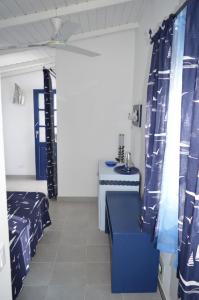 Habitación con cortinas azules y blancas y mesa. en Yacht Club Sal en Palmeira