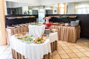 una línea de buffet con platos de comida en las mesas en Hotel Lido Europa, en Riccione