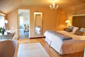a bedroom with a bed and a desk and a room at Spring Water Barn in Helston