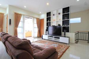 a living room with a couch and a flat screen tv at Springhill Villa Syariah in Bandung
