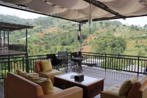 a living room with couches and a balcony with a view at Springhill Villa Syariah in Bandung