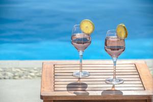 dois copos de vinho com uma fatia de limão numa bandeja em Natura Villas in Naxos em Mikri Vigla