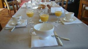 a table with cups and glasses of orange juice on it at Chambres d'hôtes Le Bignon in Villaines-la-Juhel