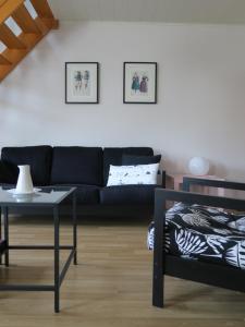 sala de estar con sofá negro y mesa en Kerhervé, en Cléden-Poher