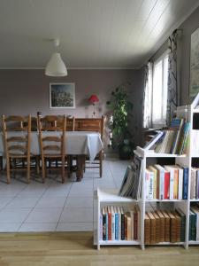 a dining room with a table and some books at Kerhervé in Cléden-Poher