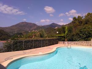 a swimming pool with mountains in the background at Costa Morroni in Levanto