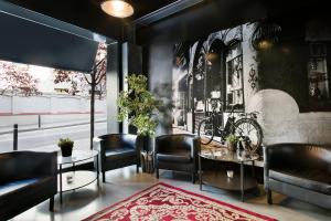 a lobby with black leather chairs and tables and a bicycle mural at Fira Apartments by gaiarooms in Barcelona