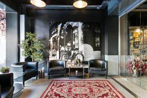 a lobby with chairs and a table and a wall mural at Fira Apartments by gaiarooms in Barcelona