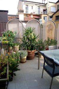 a patio with potted plants and a table and chairs at The Jasmine Terrace Retreat in Bologna