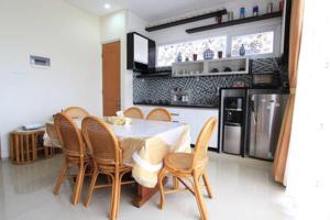 a kitchen with a table and chairs and a refrigerator at Springhill Villa Syariah in Bandung