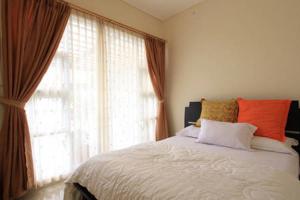 a bedroom with a bed and a large window at Springhill Villa Syariah in Bandung