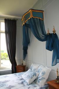 una camera da letto con letto e tende blu di Château du Clos Mortier a Saint-Dizier