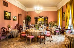 a dining room with tables and chairs and a chandelier at Pakruojis Manor's Palace Boutique Hotel in Pakruojis