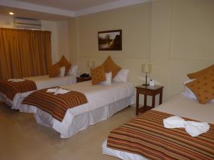 
a hotel room with two beds and two lamps at Hotel Astur in Salta
