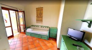um quarto com uma pequena cama e uma televisão em Villaggio Piscina Rei em Monte Nai