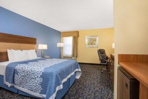 a hotel room with a bed and a desk at Days Inn by Wyndham Raleigh-Airport-Research Triangle Park in Morrisville
