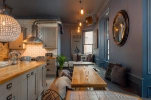 uma cozinha com uma mesa e uma sala de estar em The Baxter Hostel em Edimburgo