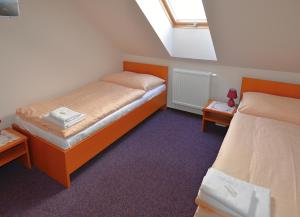 a small bedroom with two beds and a window at Apartmany Broma in Liptovský Mikuláš