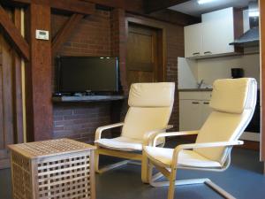 a room with two chairs and a tv and a table at Das Kleine Glück in Bullange