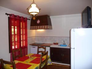a kitchen with a table and a refrigerator at Le coin tranquille in Vidauban