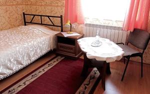 a bedroom with a bed and a table and a chair at Hotel Miły in Krosno