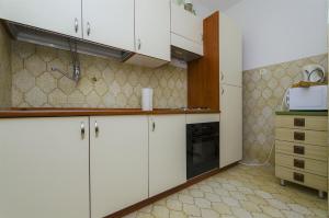 a kitchen with white cabinets and a sink at House Marija in Trogir