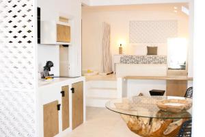 eine Küche und ein Wohnzimmer mit einem Glastisch in der Unterkunft Anatoli Luxury Studios & Suites in Astypalea-Stadt